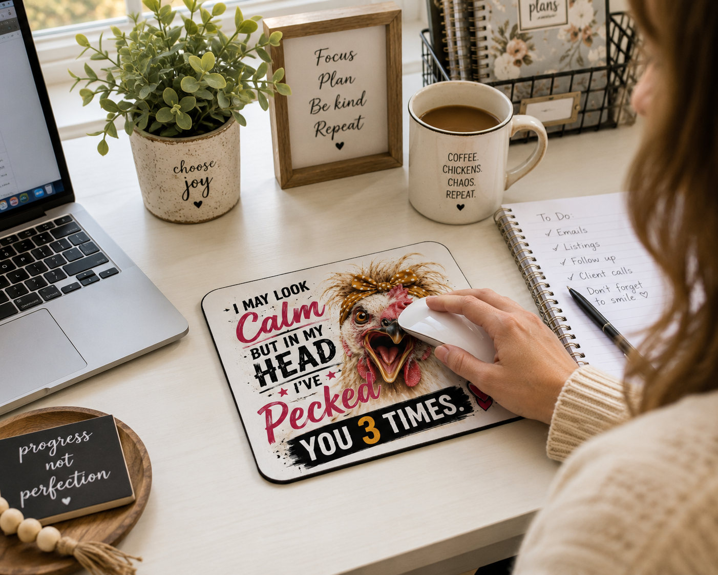Woman using a funny chicken mouse pad while working in a bright farmhouse-style home office.