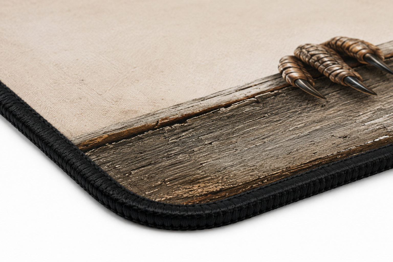 Close-up of a mouse pad corner showing a beige surface printed with a rustic brown wood texture and a black braided border, with three claw graphics along the edge.